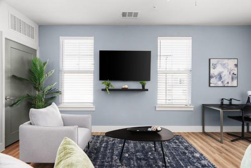 a living room with a tv on a blue wall at 1B 1B Round Rock Pool, Sauna, On-Site Coffee Shop in Pflugerville