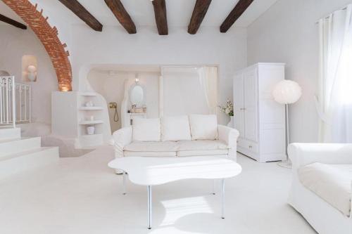 a white living room with a white couch and a table at Le Rom Antique in Grasse