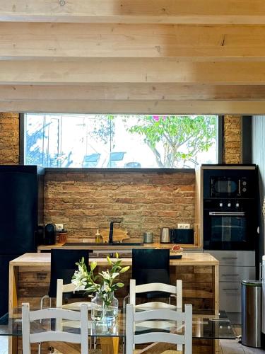 a kitchen with a table and chairs and a counter at Casa da Artista - Stylish House with Plunge Pool and Lush Garden close to Beach in Estômbar