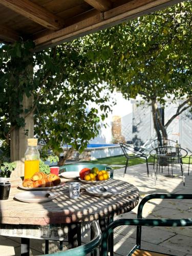 an outdoor table with a plate of fruit on it at Casa da Artista - Stylish House with Plunge Pool and Lush Garden close to Beach in Estômbar