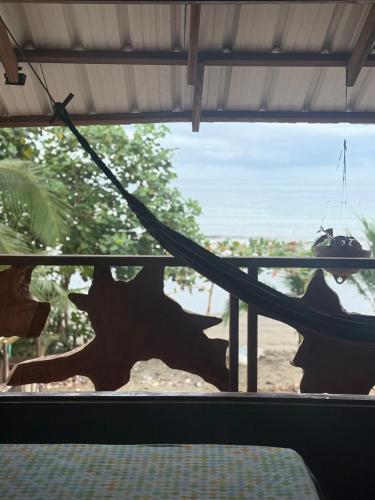 a hammock in a room with a view of the beach at La Bamba in Termales - agua caliente - nuqui
