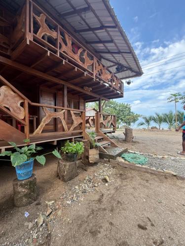 a wooden building with potted plants in front of it at La Bamba in Termales - agua caliente - nuqui