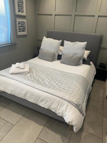a large bed with two towels on top of it at Modern Annex in Kent