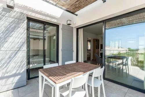 einen Esstisch und Stühle auf einem Balkon mit Aussicht in der Unterkunft Résidence Les Cyclistes, appartement La Musette in Malaucène