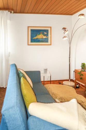 a blue couch sitting in a living room at Homestay - Panoramablick über Büdingen in Büdingen