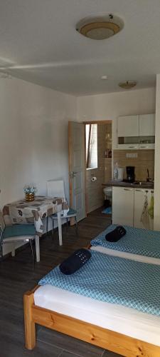 a room with two beds and a table and a kitchen at Villa Fonyód in Fonyód