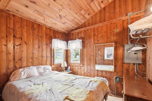 una camera da letto con un letto in una parete di legno di Beachside Cottages for Groups- Sleeps up to 40 a Lincoln Junction