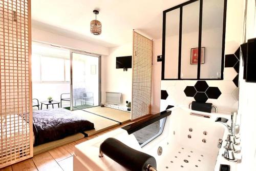- une chambre avec une baignoire et un lit dans une pièce dans l'établissement Ryokan Experience, à Saint-Raphaël