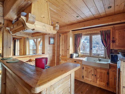 - une cuisine avec un grand comptoir en bois dans une cabine dans l'établissement Chalet cosy 4 ch ***, 8 pers, cheminée, parking, La Clusaz - FR-1-818-10, à La Clusaz
