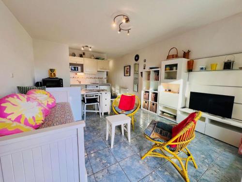 un salon avec un canapé et des chaises et une cuisine dans l'établissement Appartement 2 pièces avec jardin et parking, proche plage et commerces à Quiberon - FR-1-478-306, à Quiberon
