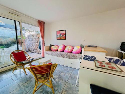 une chambre avec un lit, des chaises et une table dans l'établissement Appartement 2 pièces avec jardin et parking, proche plage et commerces à Quiberon - FR-1-478-306, à Quiberon