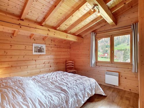 une chambre avec un lit dans une cabane en rondins dans l'établissement Demi-chalet à La Clusaz, 6 pers, 3 ch, cheminée, parking, animaux ok - FR-1-818-27, à La Clusaz