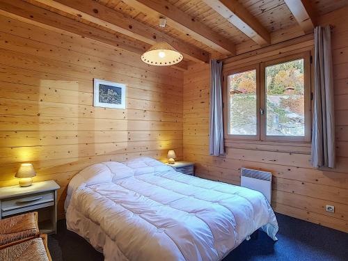 une chambre avec un lit dans une cabane en bois dans l'établissement Chalet confortable 6 pers avec cheminée, WIFI, animaux admis, parking - La Clusaz - FR-1-818-71, à La Clusaz