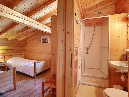 Cette cabane en rondins comprend un lit et un lavabo. dans l'établissement Chalet confortable 6 pers avec cheminée, WIFI, animaux admis, parking - La Clusaz - FR-1-818-71, à La Clusaz