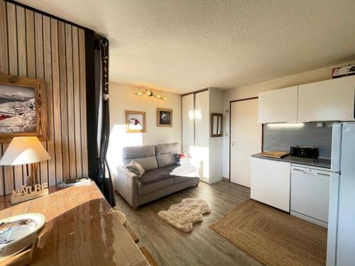 un salon avec un canapé et une cuisine dans l'établissement Studio moderne proche commodités avec parking privatif - FR-1-505-222, à Notre-Dame-de-Bellecombe
