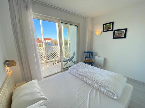une chambre avec un lit et une fenêtre avec un balcon dans l'établissement Appartement 4/5 pers, piscine, face mer, Fouras - FR-1-709-82, à Fouras