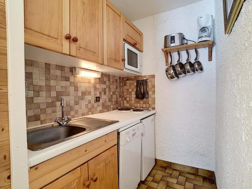 une petite cuisine avec un évier et un micro-ondes dans l'établissement Studio confortable pour 4 pers à La Clusaz, parking, classement ** - FR-1-818-65, à La Clusaz