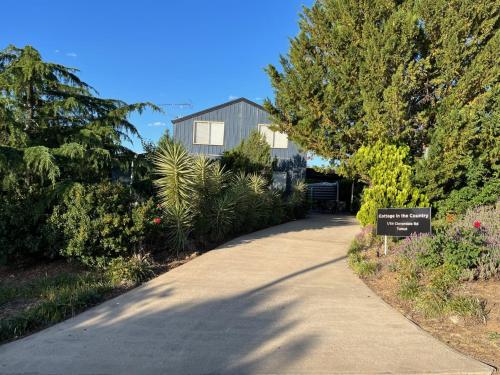 a walkway in front of a house with a sign at Cottage in the Country in Tumut