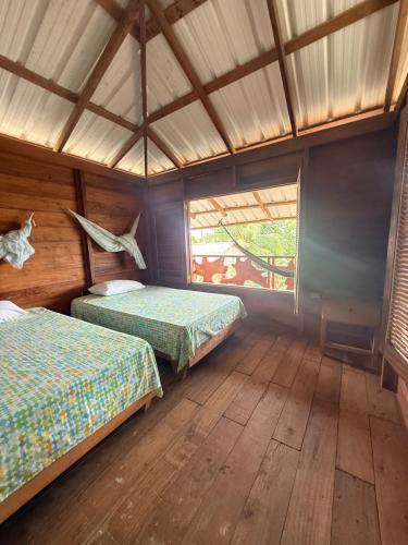 a large room with two beds and a window at La Bamba in Termales - agua caliente - nuqui