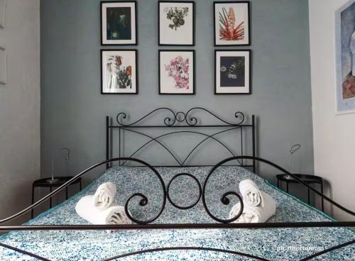 a bedroom with a black bed with pictures on the wall at Al mare da Alfred and Cate - Ampio appartamento a due passi dal Centro Storico e dalla Stazione con AC in Piombino
