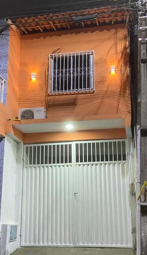 a white garage door with a window on a building at Flat Viçosa in Viçosa do Ceará