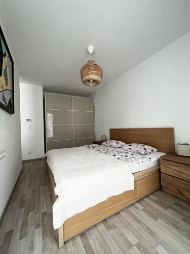 a bedroom with a large white bed and a light at MT Suites ApartHotel in Budapest