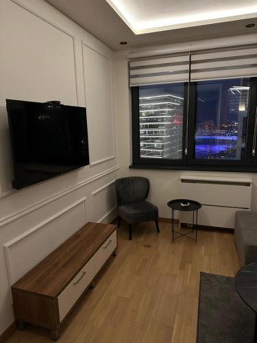 a living room with a tv and a couch and a chair at Modern Luxury in Belgrade Waterfront with Views in Belgrade