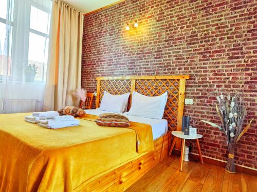 a bedroom with a bed with a brick wall at CoZy Apartments in Timişoara
