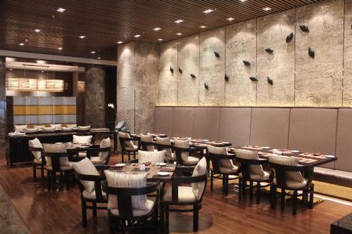 a restaurant with tables and chairs in a room at Melia Jinan in Jinan