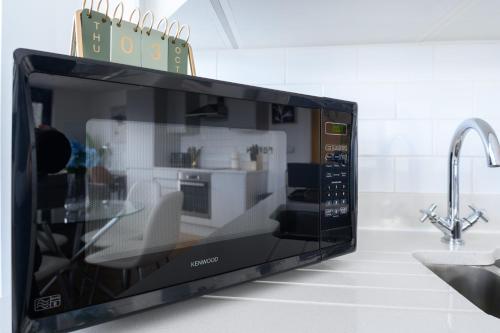 a microwave oven sitting on a kitchen counter at Luxury Penthouse with Private Hot Tub Overlooking Leeds City Centre in Leeds