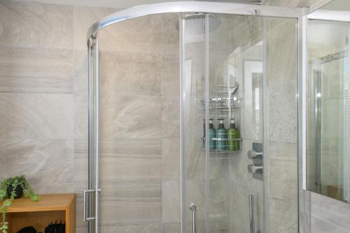 a shower with a glass door in a bathroom at Luxury Penthouse with Private Hot Tub Overlooking Leeds City Centre in Leeds