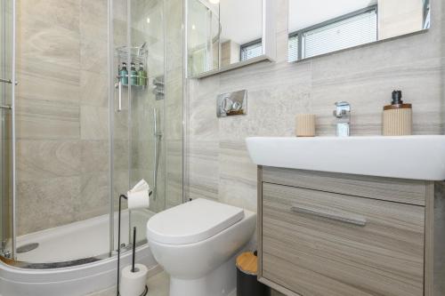 a bathroom with a toilet and a sink and a shower at Luxury Penthouse with Private Hot Tub Overlooking Leeds City Centre in Leeds