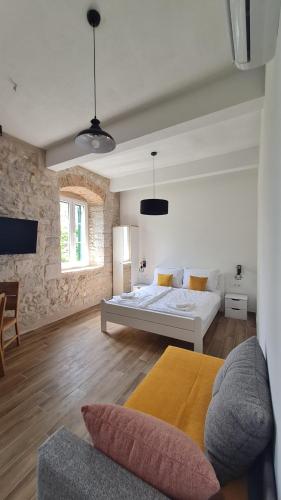 ein Schlafzimmer mit einem Bett und einer Couch in einem Zimmer in der Unterkunft Calico Apartment's in Jelsa