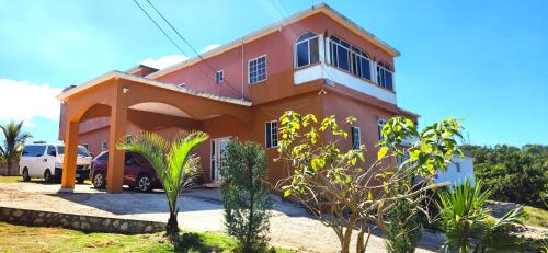 ein Haus mit einem davor geparkten Auto in der Unterkunft Swabys Hope Hideaway in Mandeville