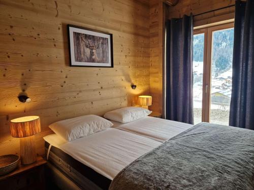 a bedroom with a bed with two lamps and a window at Chalet lumineux à Arêches-Beaufort avec terrasse et cuisine équipée - FR-1-342-332 in Beaufort