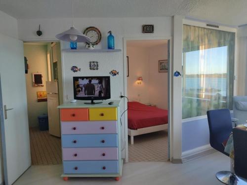 une chambre avec un lit et une télévision sur une commode dans l'établissement T2 Spacieux, Proche Plage, Parking Privé - FR-1-796-82, à Gruissan