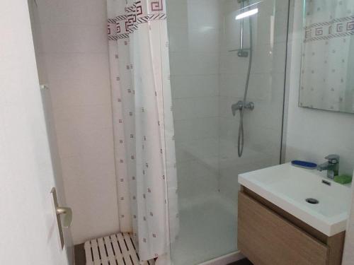 une salle de bain blanche avec une douche et un lavabo dans l'établissement T2 Spacieux, Proche Plage, Parking Privé - FR-1-796-82, à Gruissan