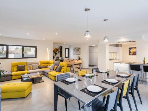 d'un salon avec une table et un mobilier jaune. dans l'établissement Gîte spacieux avec jardin, spa, babyfoot et parking privé - FR-1-306-1292, à La Haie-Fouassière