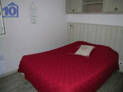 - un lit rouge avec un oreiller dans l'établissement Pavillon 300m Plage avec Piscine et Parking, Climatisation - FR-1-781-79, à Valras-Plage