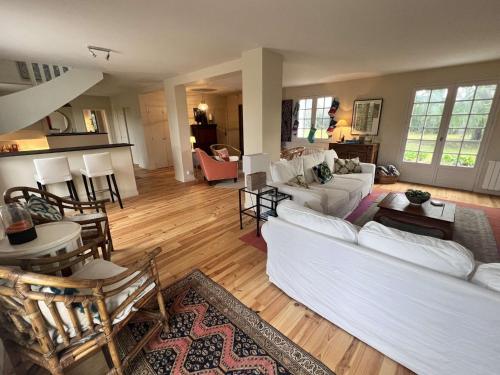 un salon avec des canapés blancs et une table dans l'établissement Maison bretonne rénovée, proche plage avec jardin et parking - FR-1-481-172, à Fouesnant