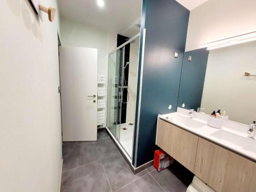 une salle de bain avec deux lavabos et une douche en verre dans l'établissement Villa moderne 3 chambres avec jardin, WiFi et parking, proche plage - FR-1-675-44, à Wimereux