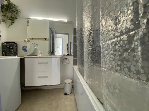 une salle de bain avec une baignoire, un lavabo et un miroir dans l'établissement Duplex T3 Vue Mer, Torrey 6, Terrasse, Parking, Barcarès - FR-1-81-629, au Barcarès