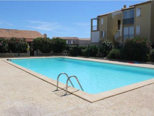 une grande piscine bleue devant un immeuble dans l'établissement Maison pour 6 à Saint Pierre la Mer avec piscine et espace extérieur - FR-1-229D-152, à Fleury