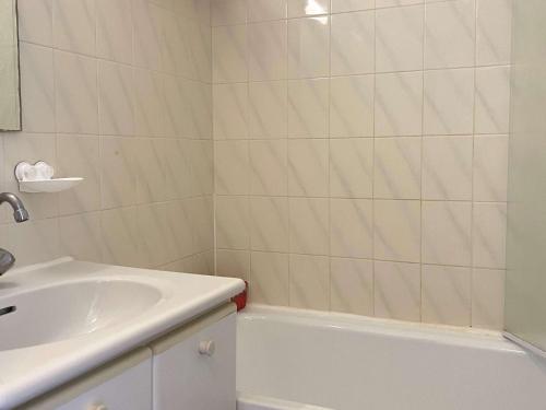 une salle de bain avec un lavabo et une baignoire dans l'établissement Studio avec Terrasse et Piscine, Parking Inclus - FR-1-553-285, à Balaruc-les-Bains