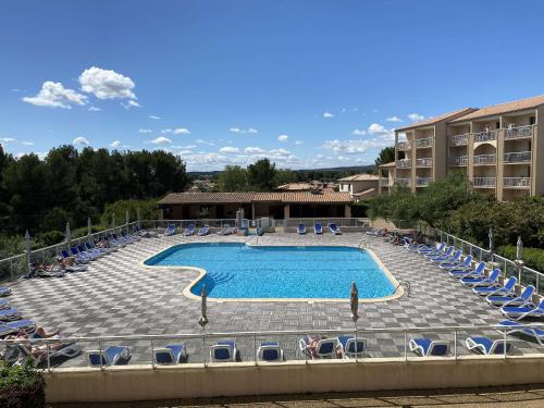 une grande piscine avec des chaises et un hôtel dans l'établissement Studio avec Terrasse et Piscine, Parking Inclus - FR-1-553-285, à Balaruc-les-Bains