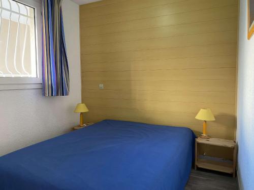 - une chambre avec un lit bleu et deux lampes dans l'établissement Appartement 2 pièces avec terrasse et piscine à Balaruc-les-Bains - FR-1-553-286, à Balaruc-les-Bains