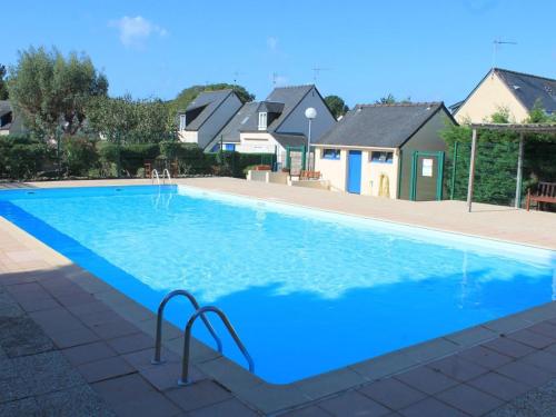 une grande piscine bleue dans une maison dans l'établissement Maison 5 pers avec piscine chauffée, près plage Sarzeau - FR-1-775-15, à Sarzeau