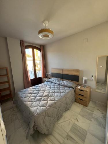 a bedroom with a large bed and a window at La Corrala de Chite in Lecrin
