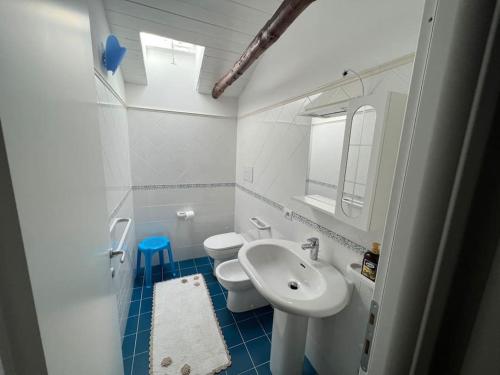 a white bathroom with a sink and a toilet at Appartamento Luna, Roccella Ionica con vista mare in Roccella Ionica