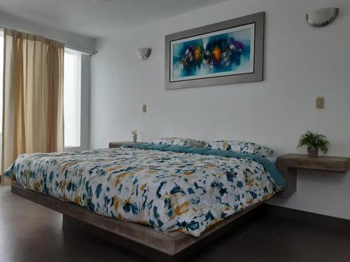 une chambre avec un lit avec une couette colorée dans l'établissement ESCAPA DE LA RUTINA Y DISFRUTA Asia - Chocaya, à Asia